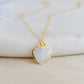 Genuine natural rainbow moonstone romantic heart gemstone pendant set on a dainty 14k gold filled cable chain. Close up image showing the blue flash within the gemstone. 