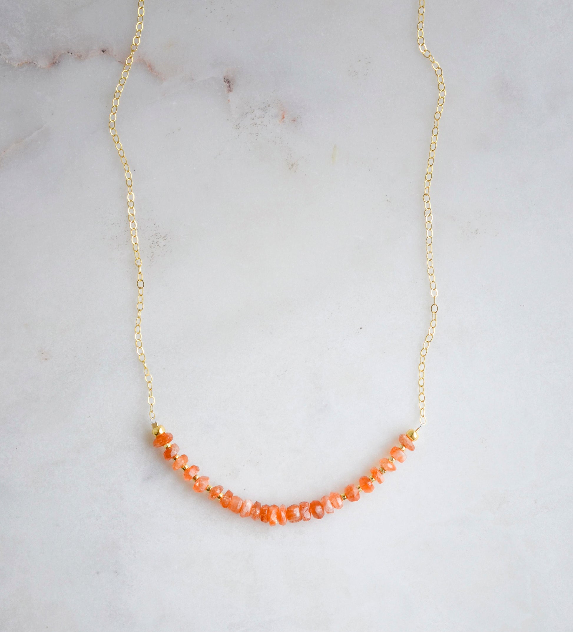 A beaded bar of sunstone crystals set on a gold filled chain.