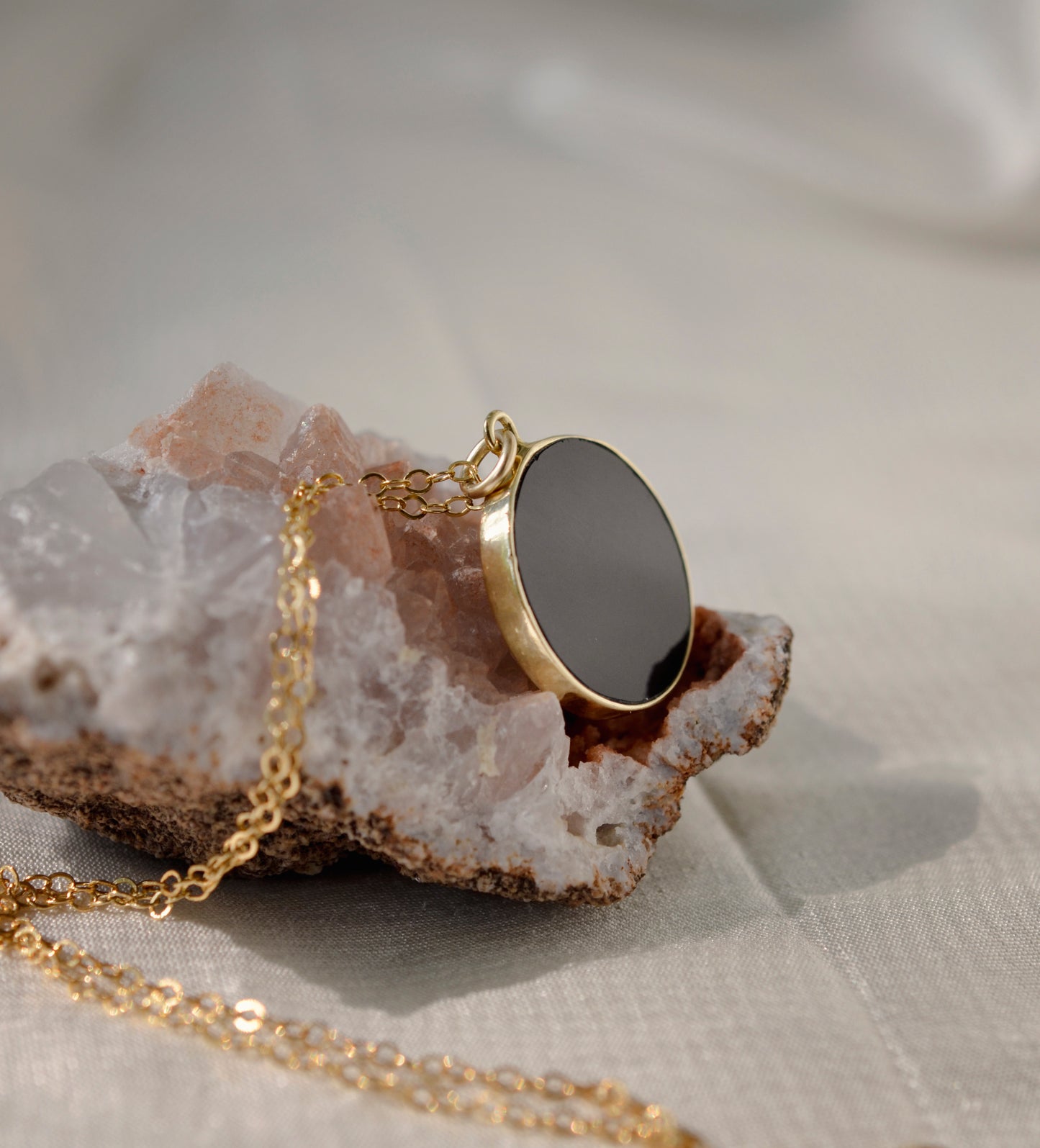 Smooth Polished Black Onyx Circle Pendant on Simple Gold Chain.