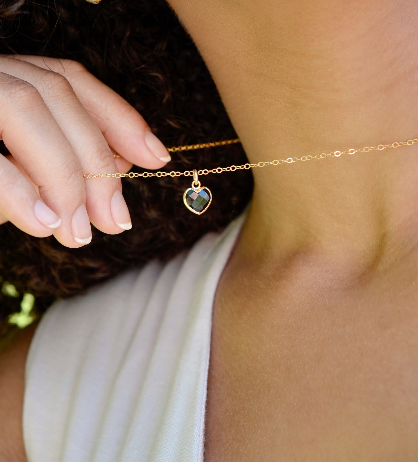 Black Onyx gold heart necklace. A black stone heart bezeled in gold is suspended from a 14k gold filled chain.