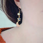 Mother of pearl, Labradorite, and Peach Moonstone moon and star dangle earrings in gold. Each earring has two stars hanging over a peach moonstone crescent. Modeled image.