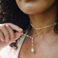 White freshwater pearl necklace with a large coin pearl pendant. Pearls fill one side of the necklace, while the other side is a dainty gold chain. Modeled image.