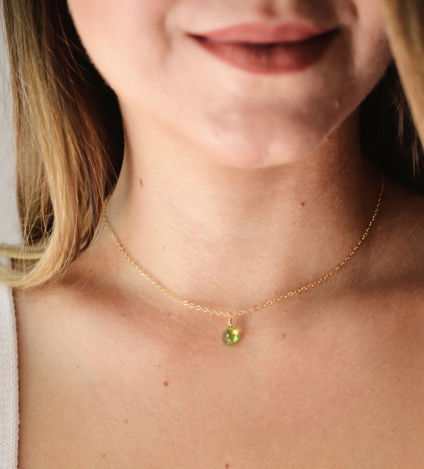 Natural green Peridot faceted teardrop suspended from a 14k gold filled cable chain. Modeled image.