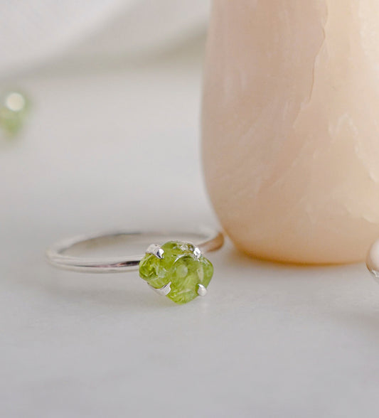 Raw green peridot ring on a sterling silver band. Close up image.