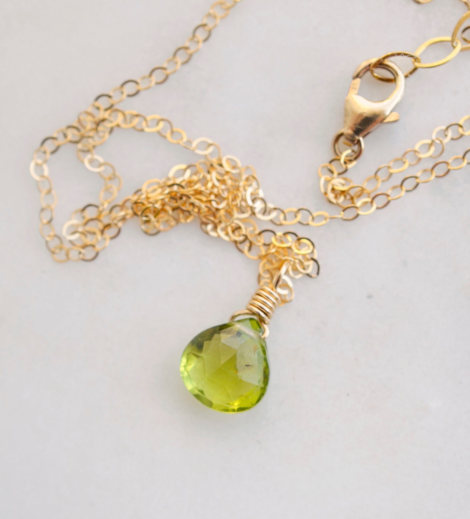 Natural green Peridot faceted teardrop suspended from a 14k gold filled cable chain.