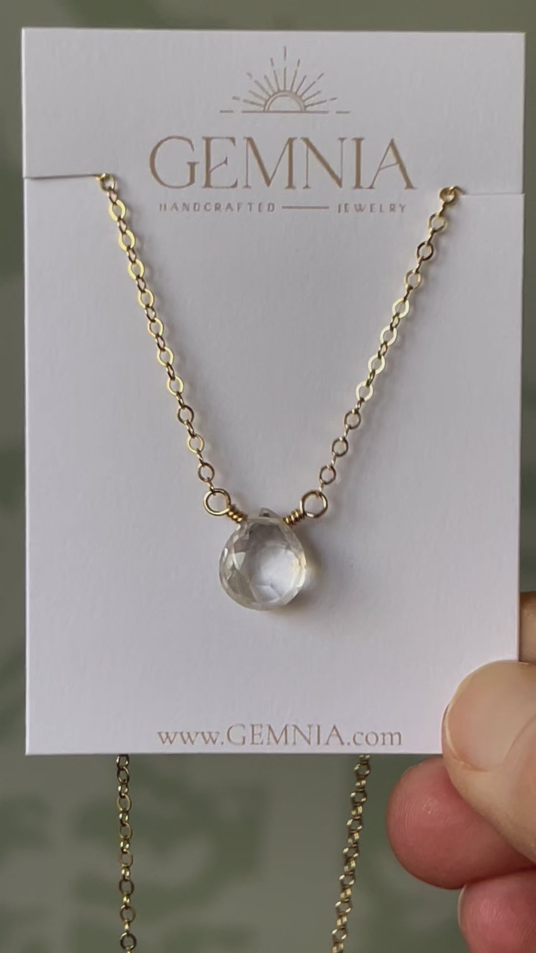 A clear, natural crystal quartz faceted teardrop set onto a 14k gold filled chain. Movie.