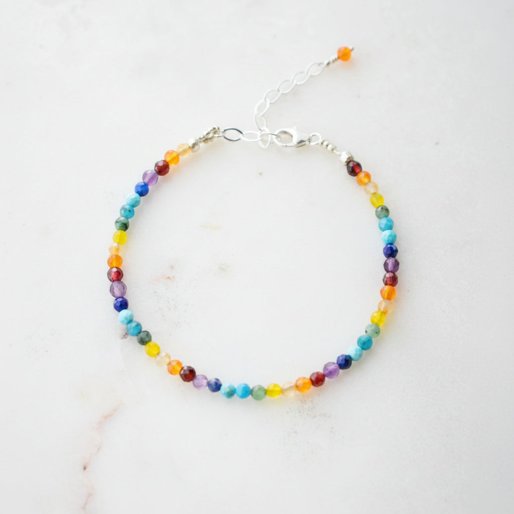 Tiny gemstone beaded bracelet in rainbow colors. Colors include: blue, green, yellow, red, orange, and purple.