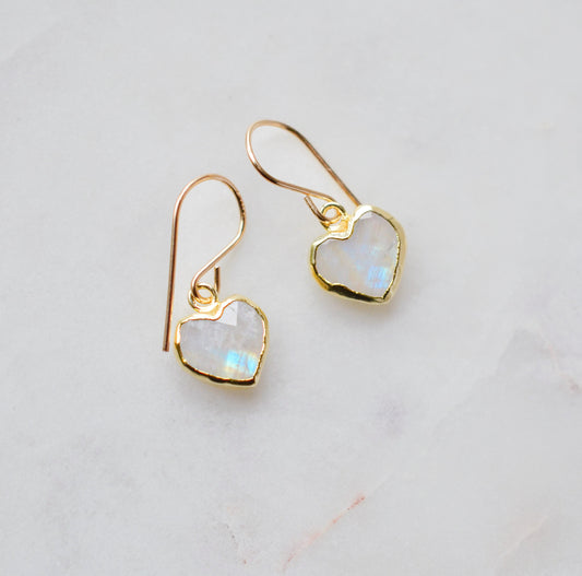 Natural rainbow moonstone stone heart earrings in gold. The stones are white, but flash blue with movement.