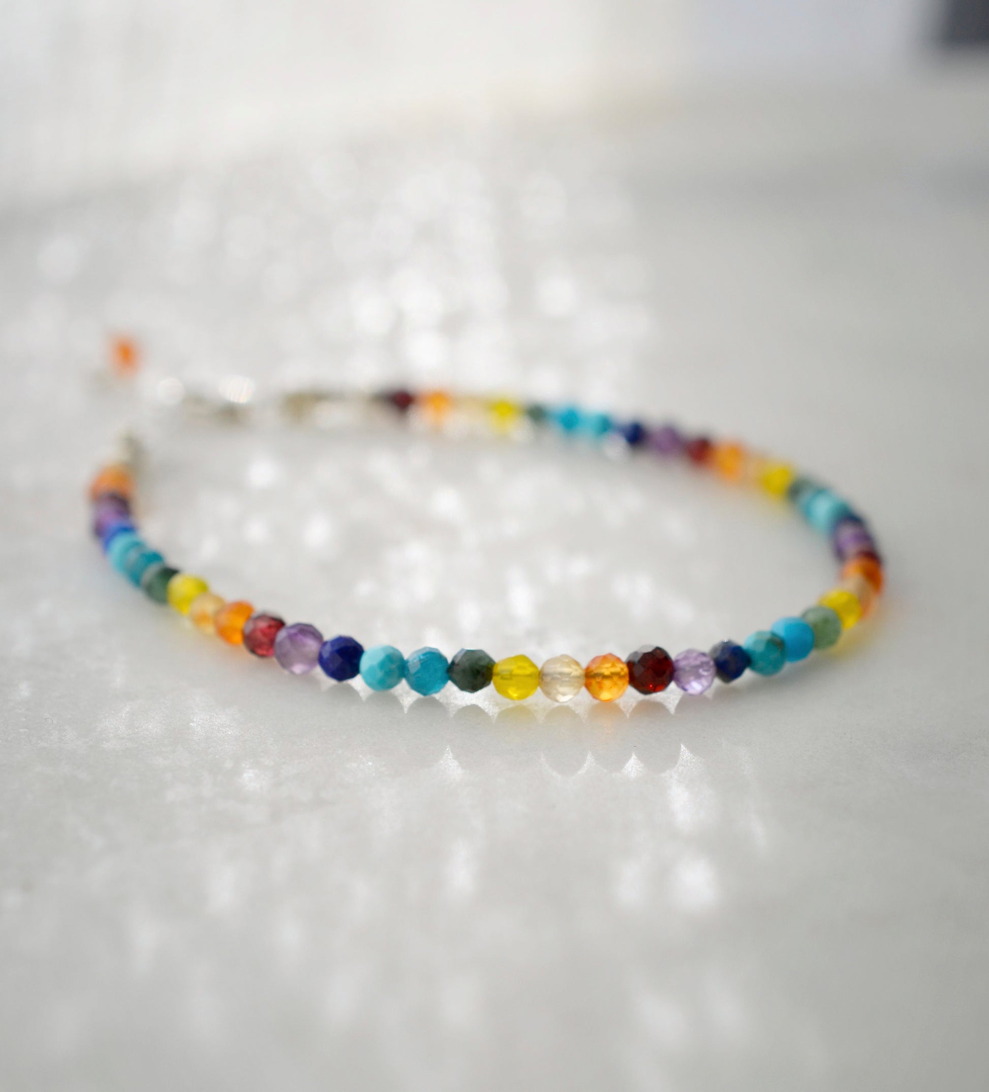 Tiny gemstone beaded bracelet in rainbow colors. Colors include: blue, green, yellow, red, orange, and purple.