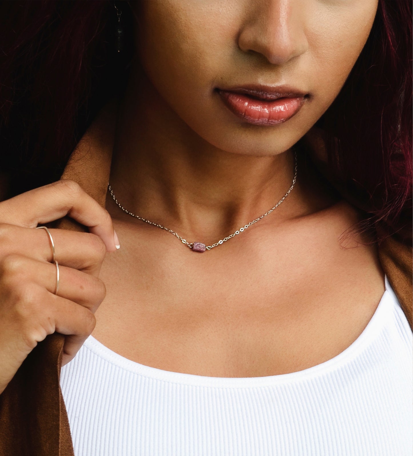 Small natural pink tourmaline crystal set onto a sterling silver chain.  Modeled image.