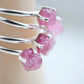 Close up of multiple rings with rough Pink Tourmaline gemstones set in sterling silver.