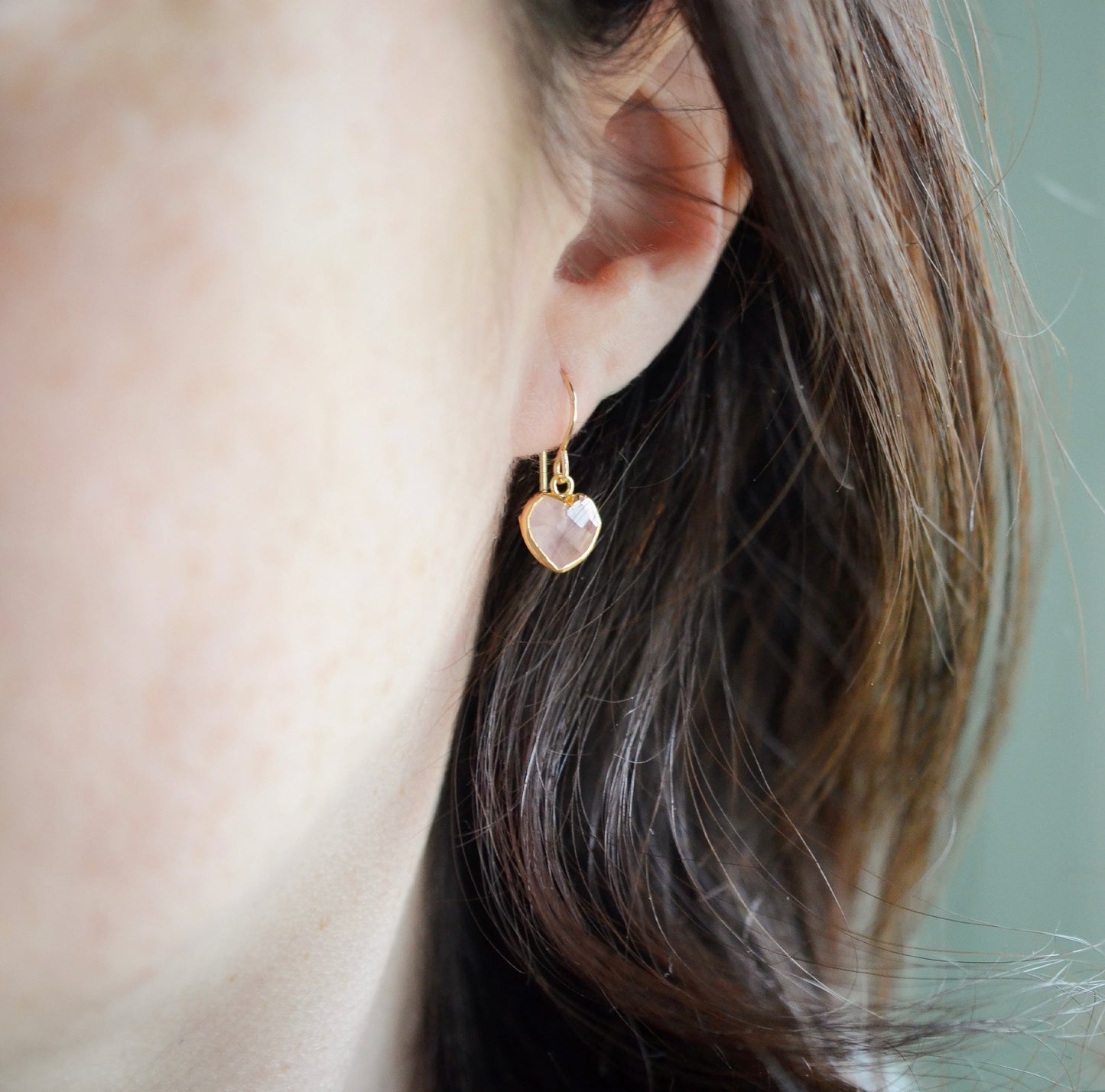 Dainty, handcrafted rose quartz heart earrings featuring a faceted, sparkling heart—the stone of universal love. These gentle dangles, approximately 0.5 inches (12mm/1.2cm) in size, are modeled in 14k gold filled and are also available in sterling silver. They make a sweet and thoughtful gift for someone special. 