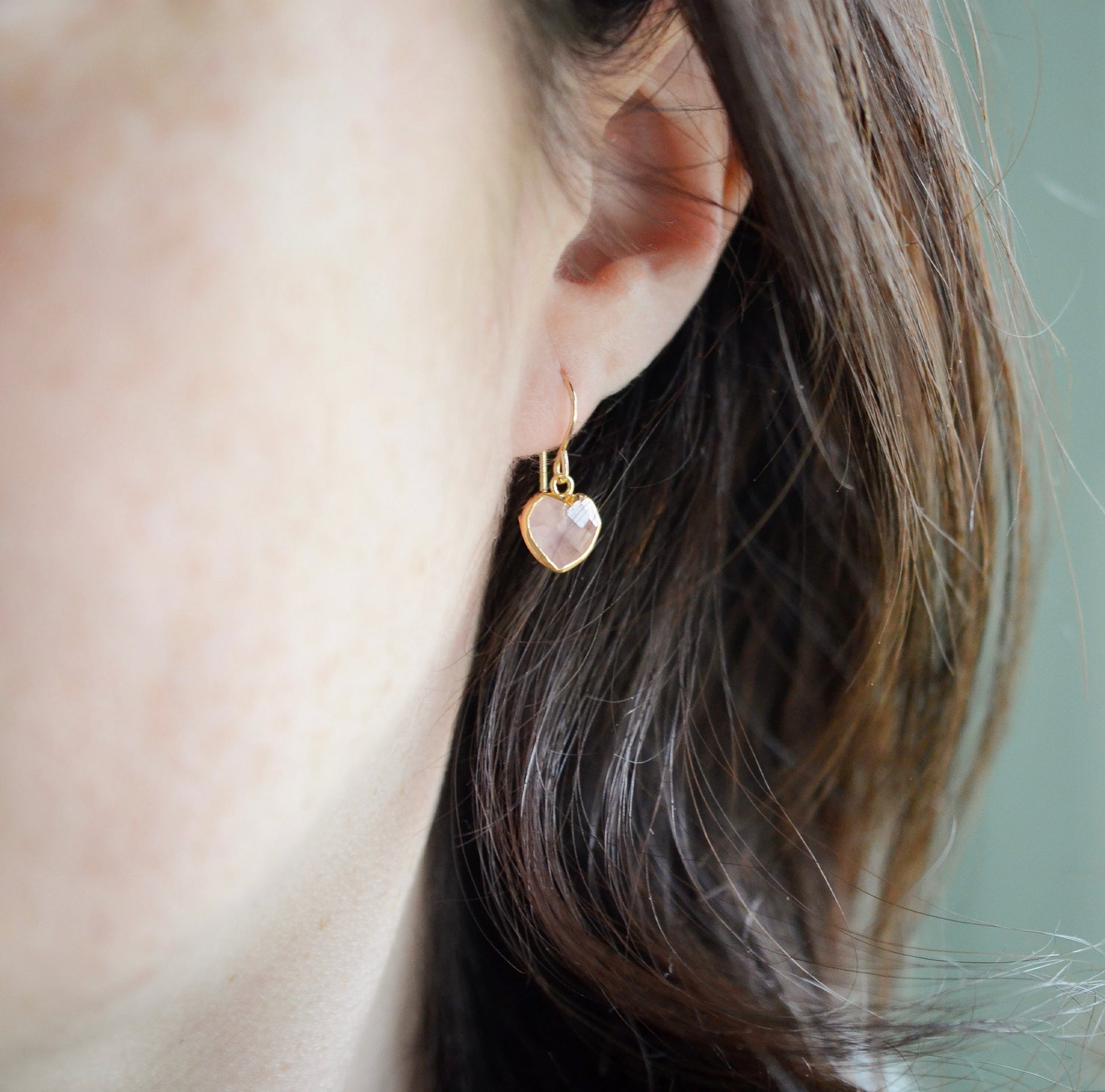 Dainty, handcrafted rose quartz heart earrings featuring a faceted, sparkling heart—the stone of universal love. These gentle dangles, approximately 0.5 inches (12mm/1.2cm) in size, are modeled in 14k gold filled and are also available in sterling silver. They make a sweet and thoughtful gift for someone special. 