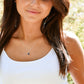 Woman wearing a necklace with a star pendant outdoors. Modeled in sterling silver.