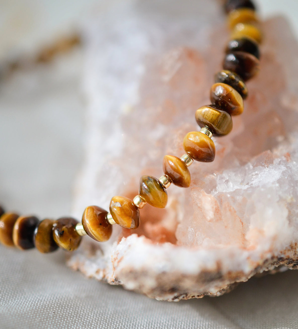 A close up image of a natural beaded tiger eye necklace in gold. All jewelry is handcrafted by Gemnia in Connecticut.