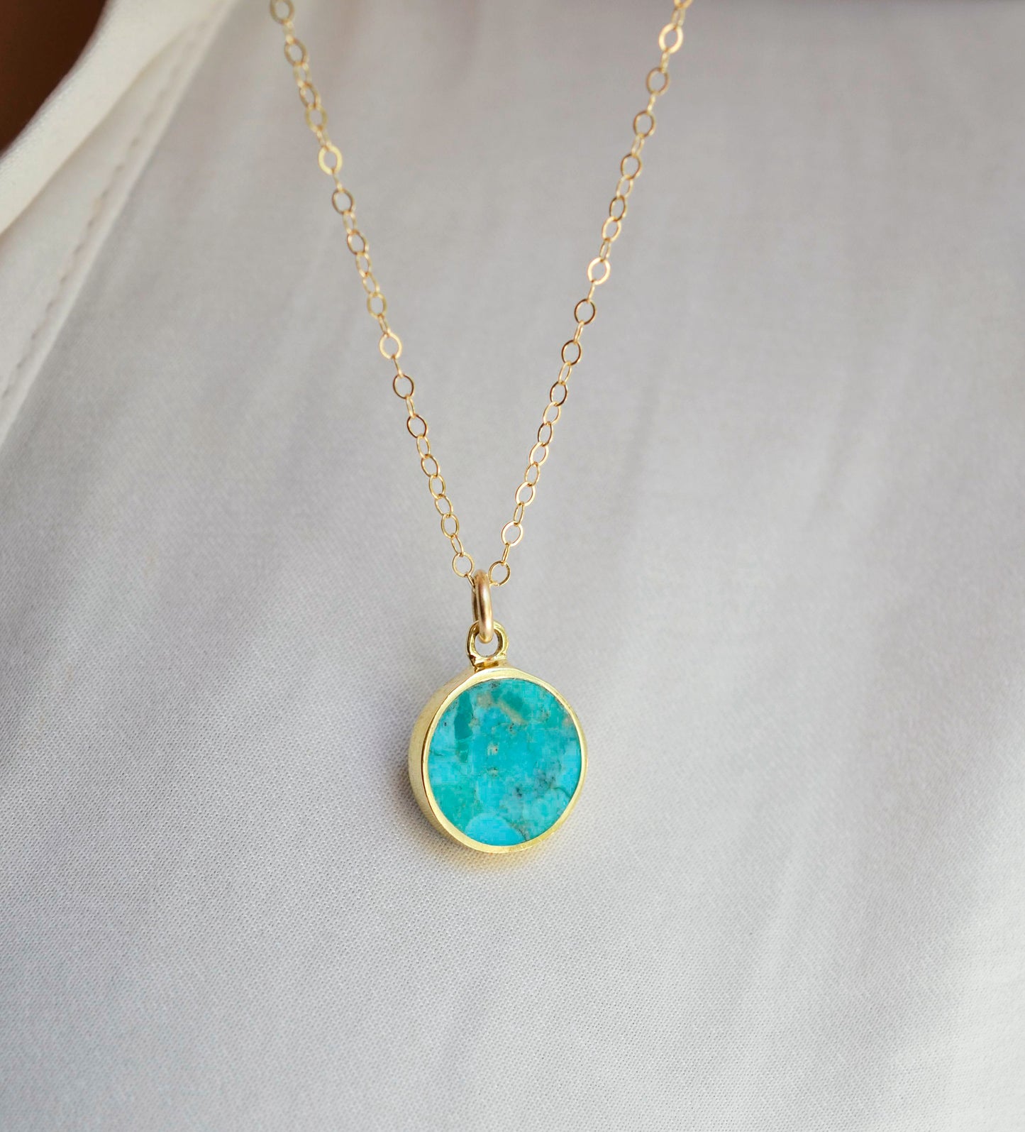 Round aqua blue Turquoise set into a gold bezel and suspended from a 14k gold filled chain.