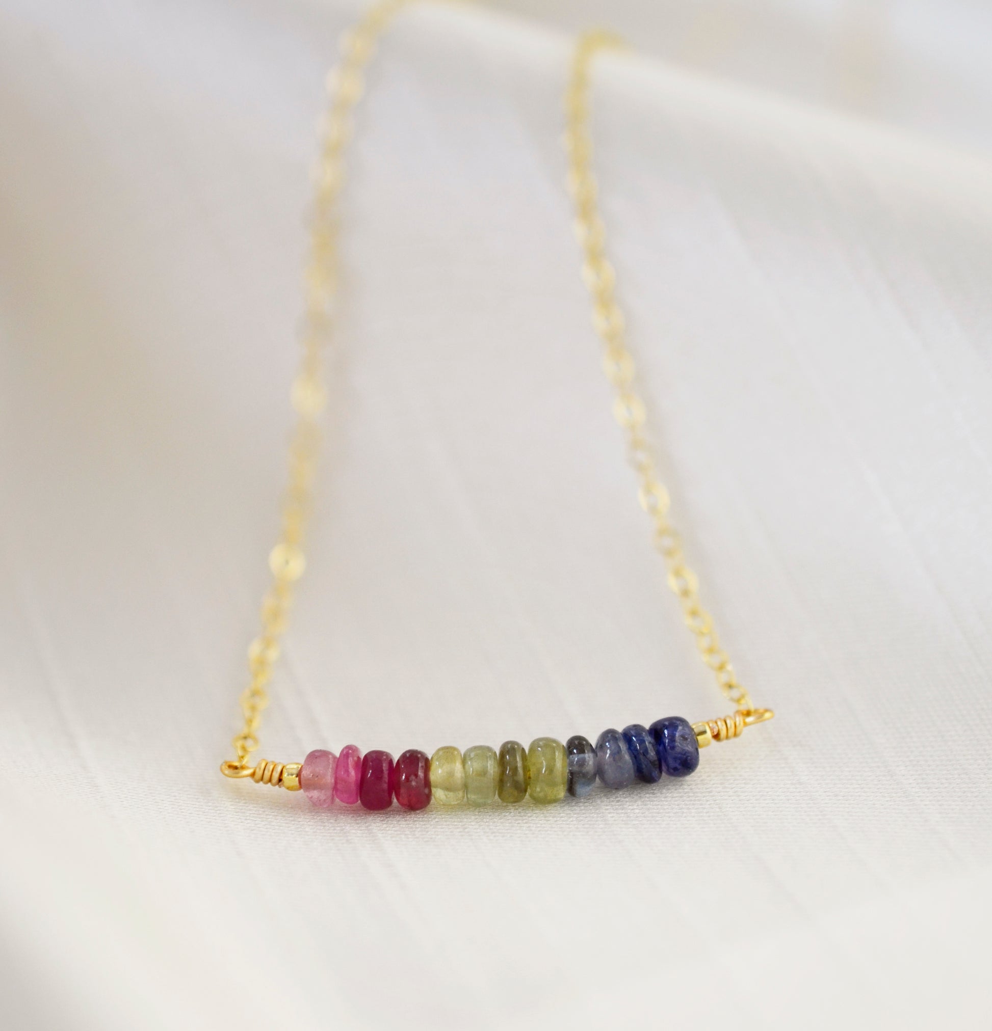 Multi color sapphire necklace. Blue, pink, green, yellow sapphires arranged into a bar pendant. Made in Sterling Silver or Gold Filled.