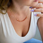 Handmade sunstone necklace featuring a row of beaded natural crystals. Modeled image.