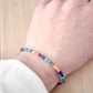 A handmade, beaded, multi-color gemstone bracelet depicting the rainbow, pride, or the chakras. Natural crystals include: turquoise, apatite, emerald, garnet, yellow opal, amethyst, aventurine, and lapis lazuli. Handcrafted in Connecticut by Gemnia Jewelry.