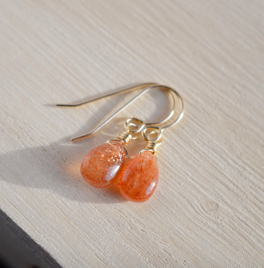 Genuine, smooth polished orange Sunstone teardrops suspended from 14k gold filled earwires.