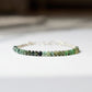 A raw emerald bracelet in shades of light to dark green. Each bracelet is handmade in Connecticut, USA and is perfect for everyday stacking. Also available in 14k gold filled. 
