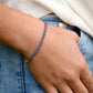 A modeled image of a woman wearing a natural Tanzanite bracelet that has been handmade and beaded with genuine stones, 14k gold filled or sterling silver, and metallic glass beads.