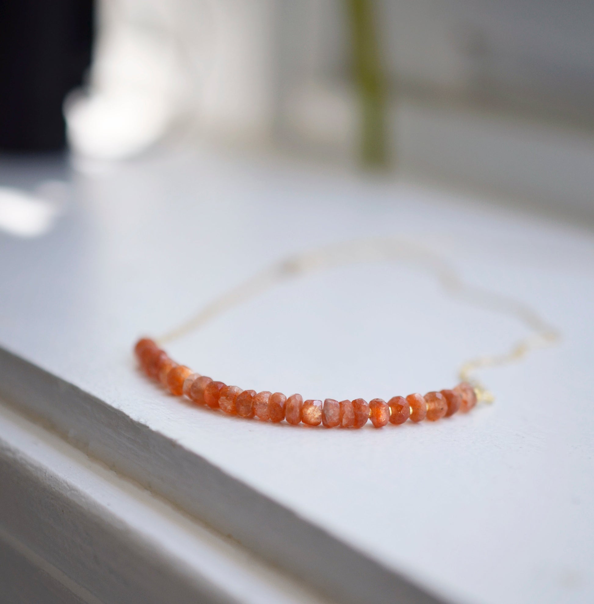 Sunstone Necklace with small faceted sunstone gems set onto a sterling silver or gold filled chain. 
